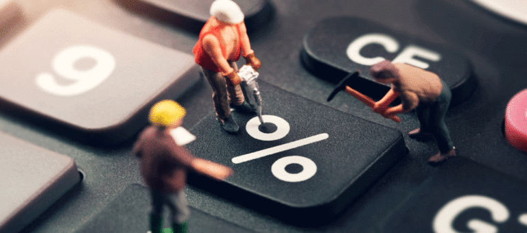 Figuras en miniatura de tres obreros trabajan, con pico y martillo hidráulico, sobre la tecla "%" de un teclado