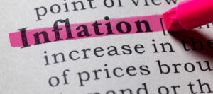 subrayando en color rojo la definición de la palabra inflación en un diccionario