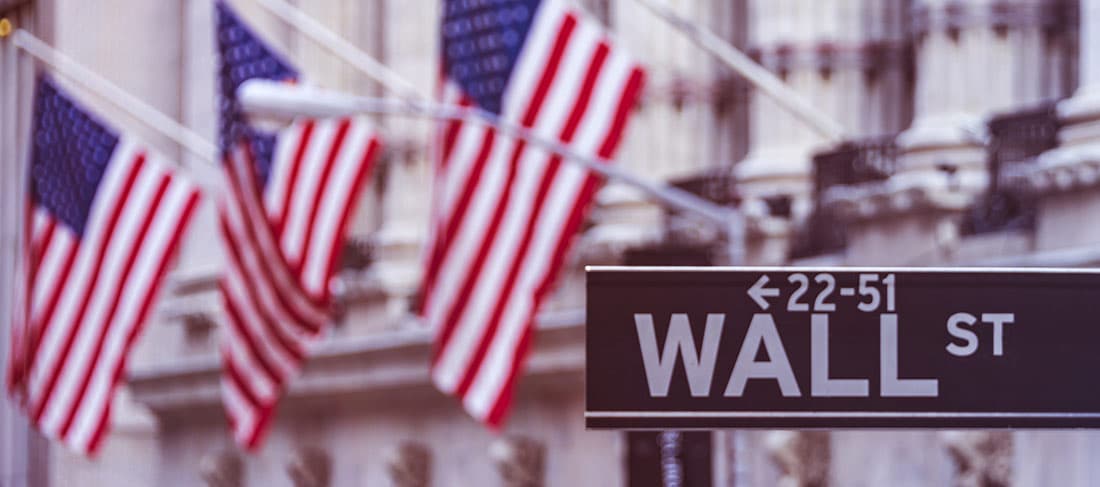 Wall Street con las banderas americanas en el fondo
