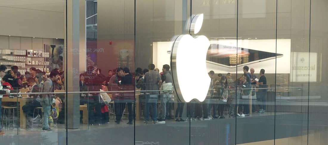 ciudadanos chinos dentro de una tienda con un gran logo de Apple en el cristal